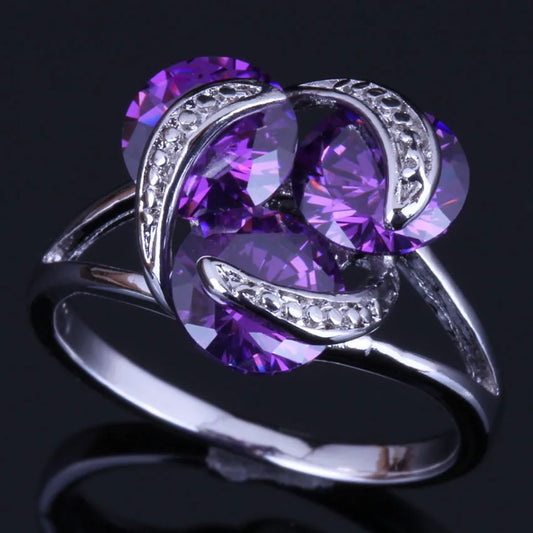 Silver plated ring with round purple cubic zirconia stones in a classic tension setting design